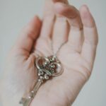 An antique skeleton key rests delicately on a person's open palm, showcasing elegant design.